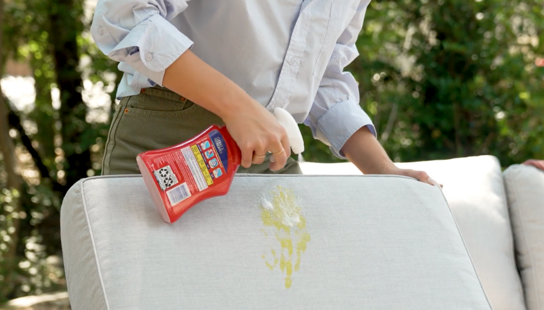 Person spraying fabric with resolve to clean it 